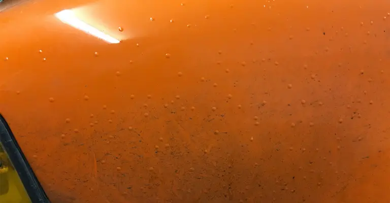 orange car paint that has multiple smaller blisters in different locations